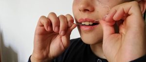 Vegane Zahnseide ohne Plastik, Junge nutzt Zahnseide